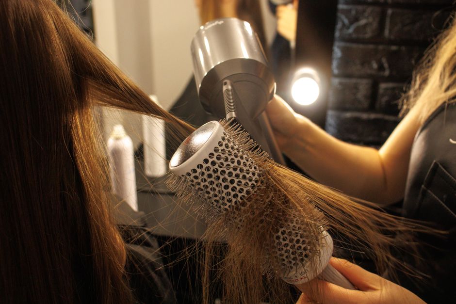 Stylist finishing a client's hair at the styling station